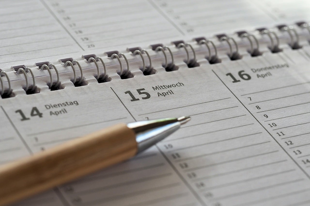 Calendario de pared abierto sobre una mesa, con los días del mes a la vista