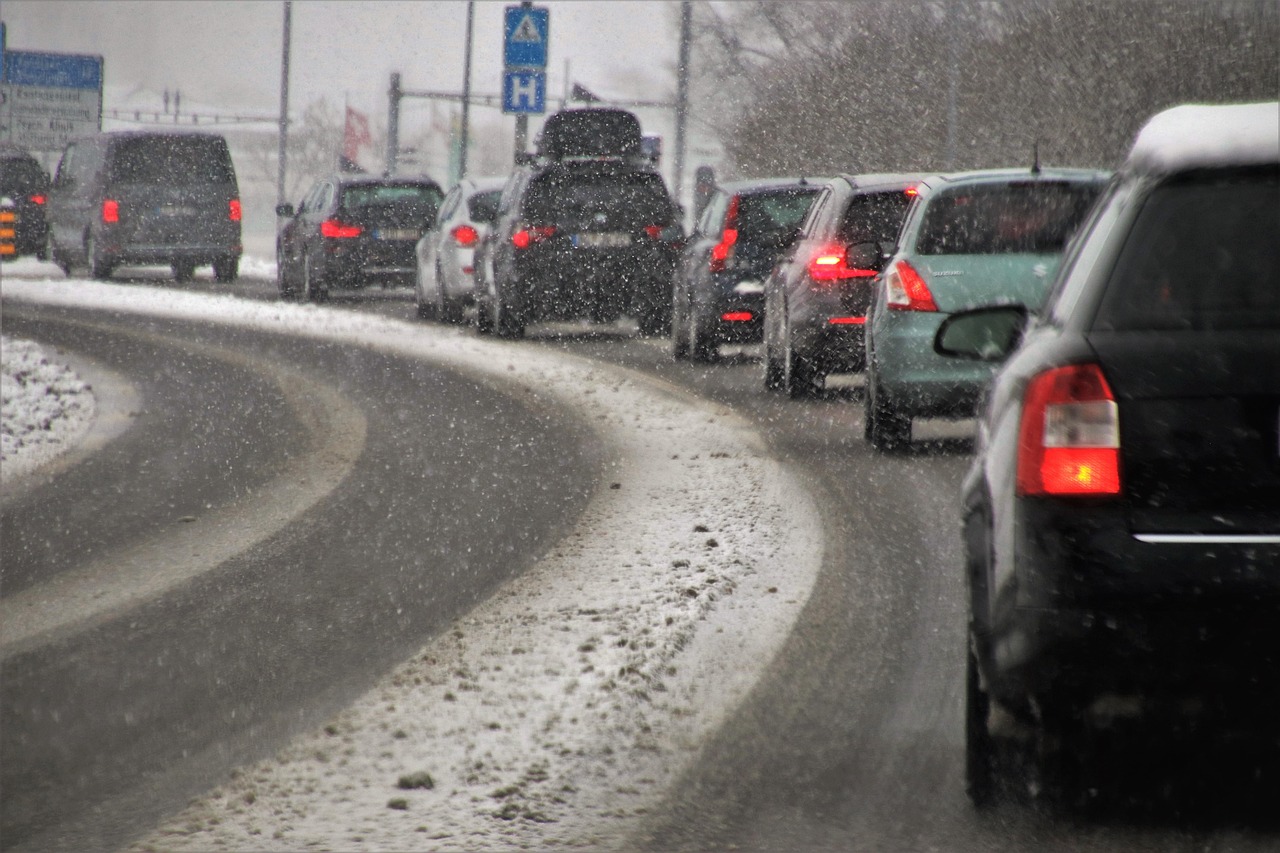 Cola de coches detenidos en una autopista de dos carriles, en un dia gris de lluvia